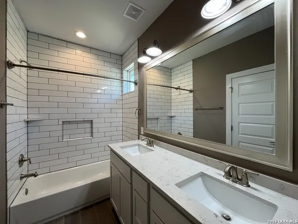 a bathroom with a bathtub and double sink