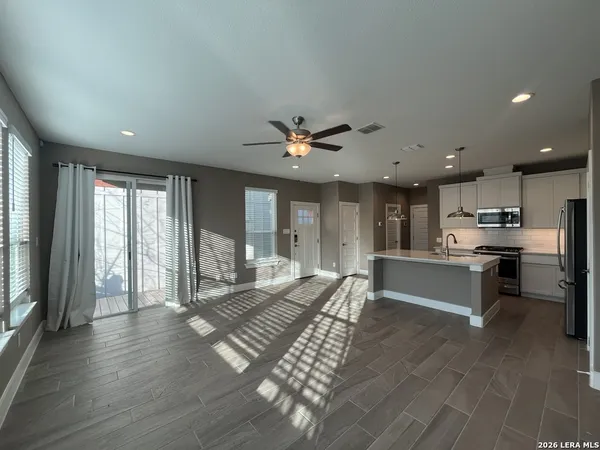 a large white kitchen with lots of counter space a sink and stainless steel appliances