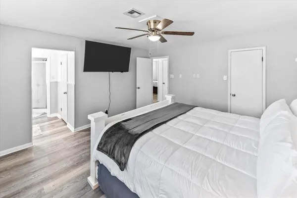 a bedroom with a bed tv and a chandelier
