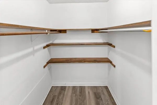 a view of walk in closet with empty racks