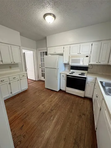 a large kitchen with a sink stove and refrigerator