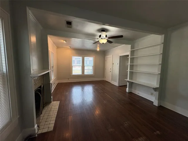 a view of an empty room with a window and wooden floor