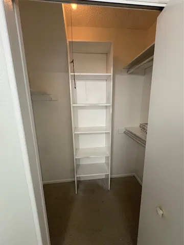 a view of an empty room with wooden floor and window