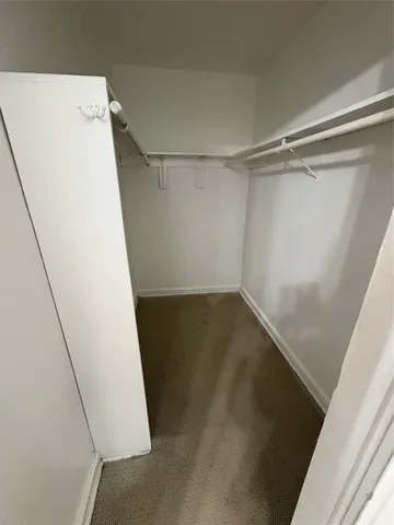 a view of walk in closet with empty racks