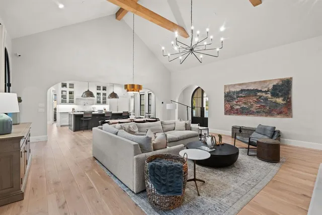 a living room with furniture a chandelier and a rug