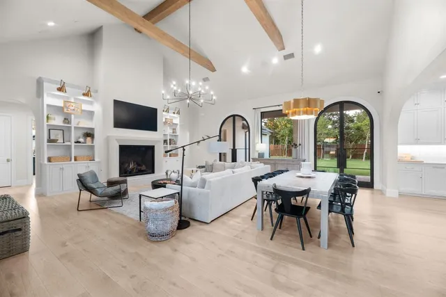 a living room with furniture a fireplace and a chandelier
