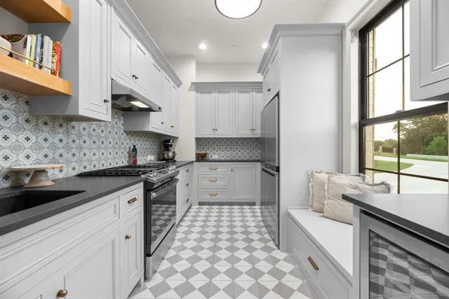 a kitchen with stainless steel appliances a sink stove and cabinets