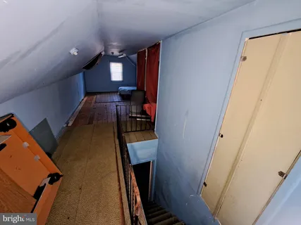 a bedroom with wooden floor and window