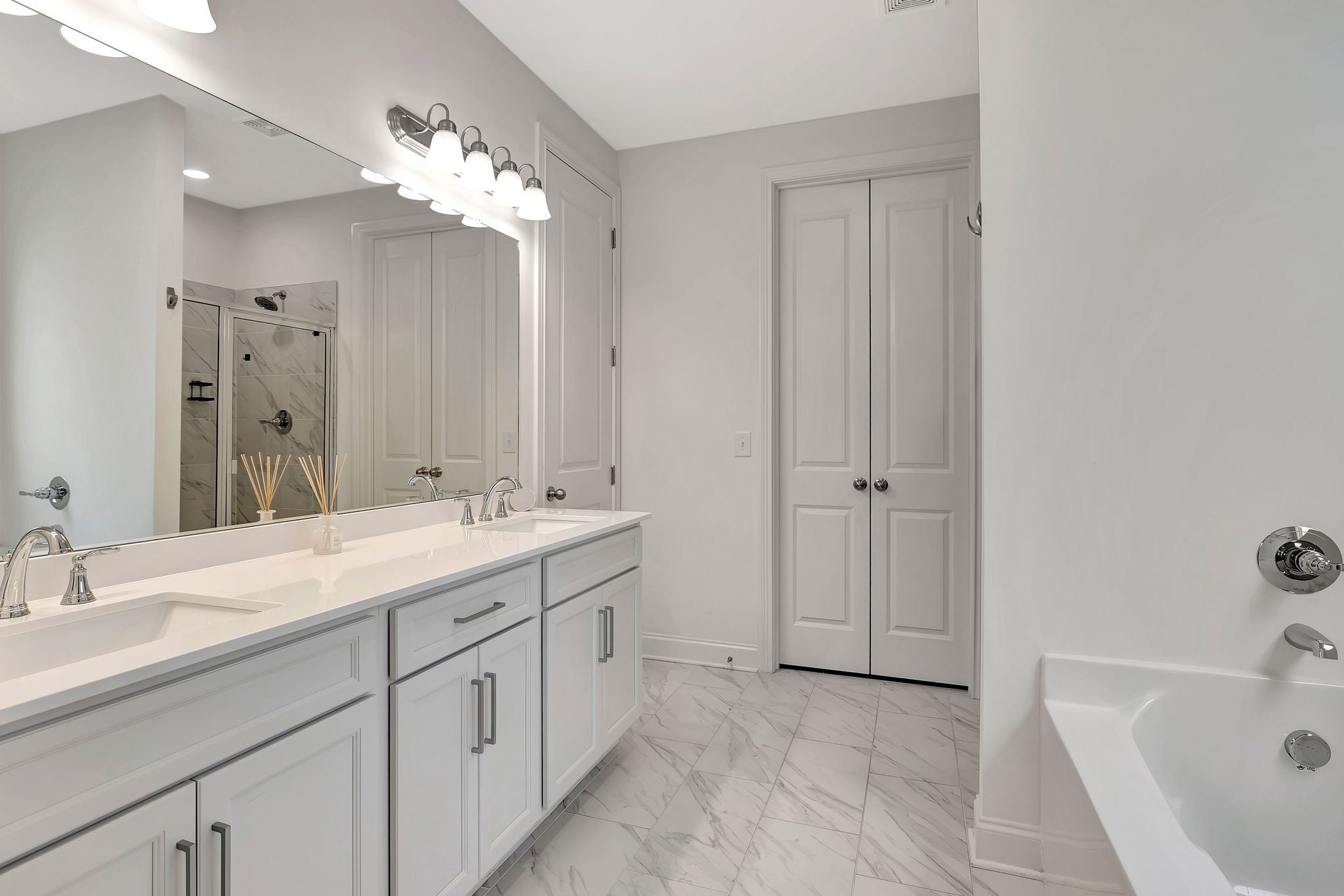 3017 Shandor St Spring Hill Spring Hill, TN 37174 - Photo 23 of 46 a bathroom with a double vanity sink a large mirror and a bathtub