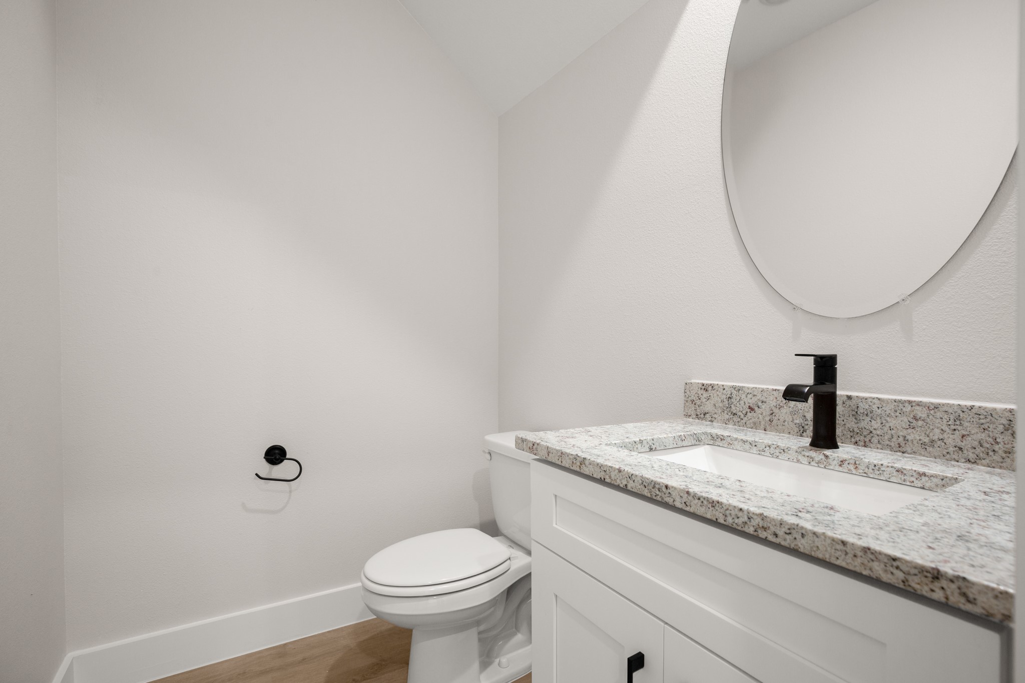 5502 Mobeetie Loop Bee Cave, TX 78738 - Photo 6 of 16 Bathroom featuring a white vanity with slab front cabinetry, black hardware, an undermount sink, and a speckled countertop