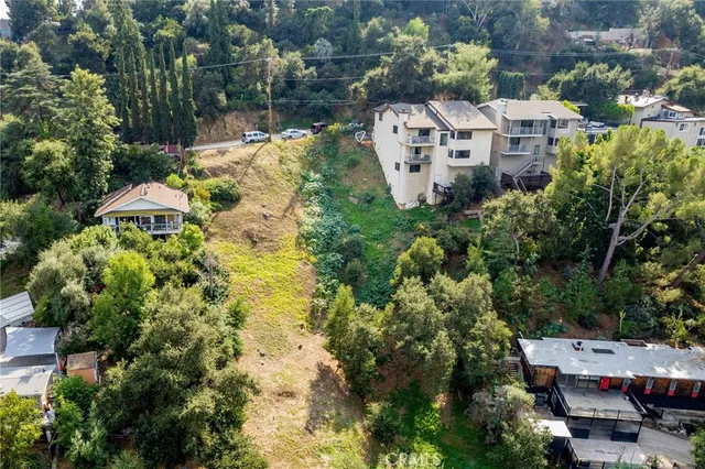 an aerial view of residential houses with yard and trees