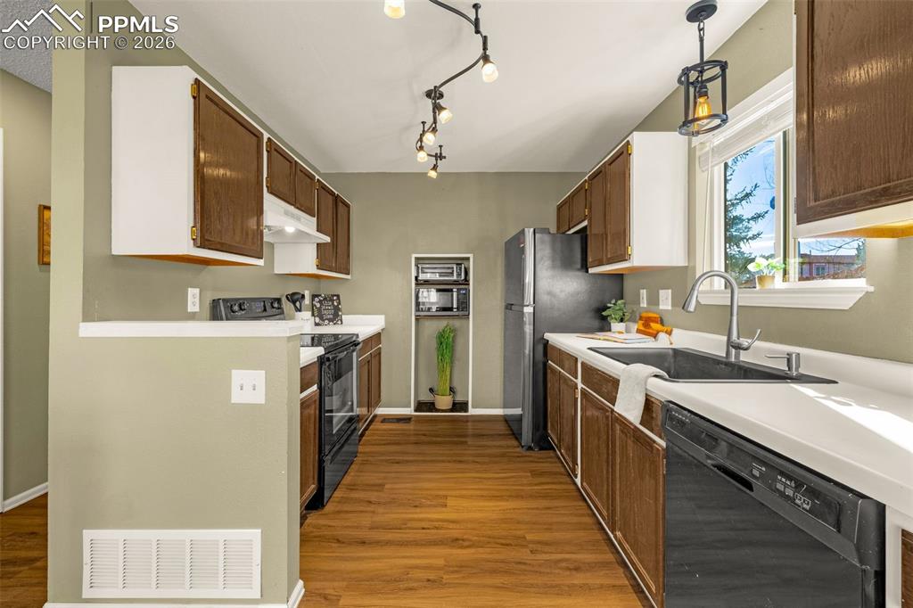 512 Harvest Moon Road Fountain, CO 80817 - Photo 9 of 41 a kitchen with stainless steel appliances granite countertop a stove a sink dishwasher and a refrigerator with wooden cabinets
