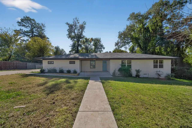 a front view of house with yard and trees