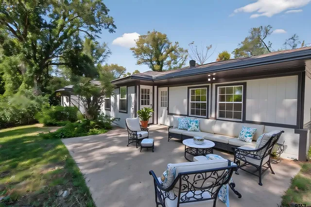 a view of a house with backyard sitting area and garden