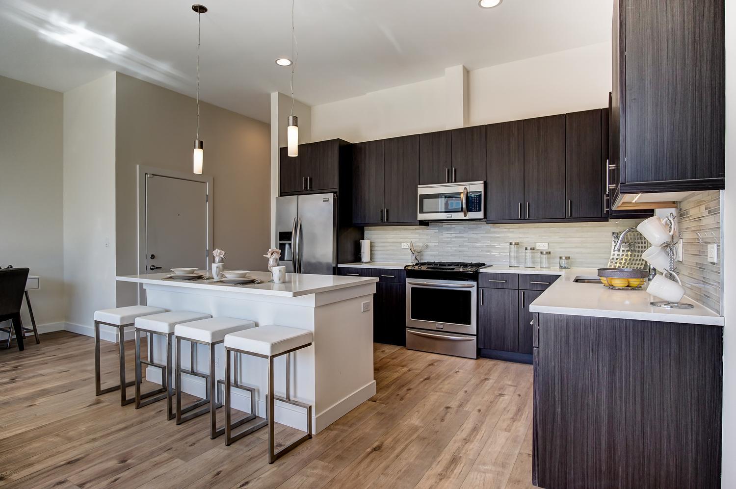 2532 West Addison Street, Unit 3E Chicago, IL 60618 - Photo 12 of 20 a kitchen with a sink stove cabinets and wooden floor