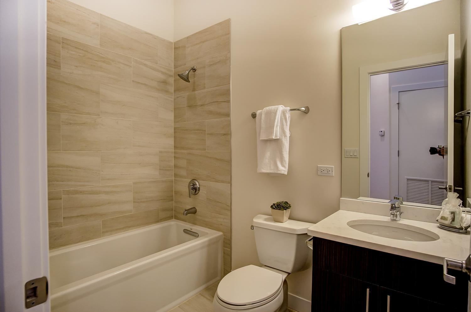 2532 West Addison Street, Unit 3E Chicago, IL 60618 - Photo 18 of 20 a bathroom with a sink toilet and shower