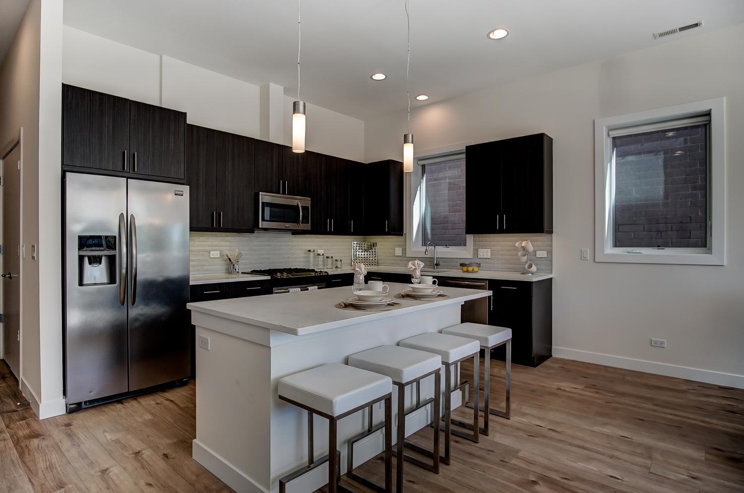 2532 West Addison Street, Unit 3E Chicago, IL 60618 - Photo 7 of 20 a kitchen with stainless steel appliances a microwave sink and refrigerator