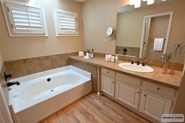 a spacious bathroom with 2 sink tub and a mirror