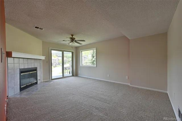 a view of an empty room with a fireplace and a window