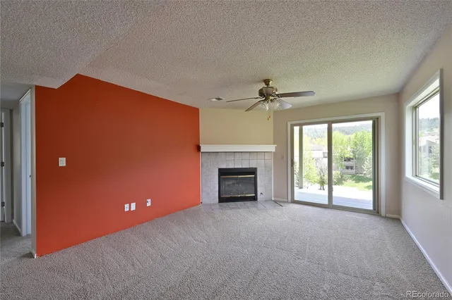 a view of an empty room with a fireplace and a window