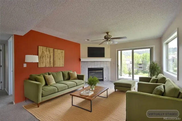 a living room with furniture a large window and a fireplace