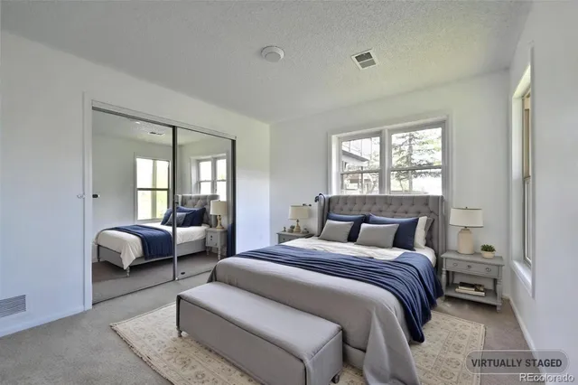 a bedroom with bed couch and window