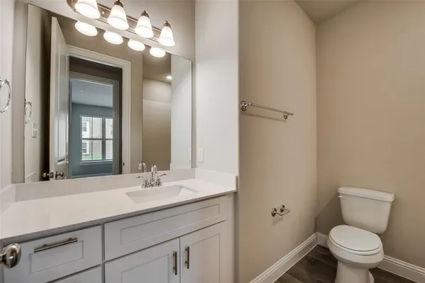 a bathroom with a toilet a sink and mirror