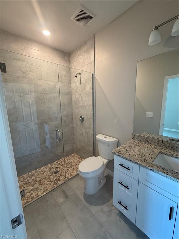 832 Holmes Avenue Lehigh Acres, FL 33974 - Photo 15 of 25 a bathroom with a granite countertop sink toilet and shower