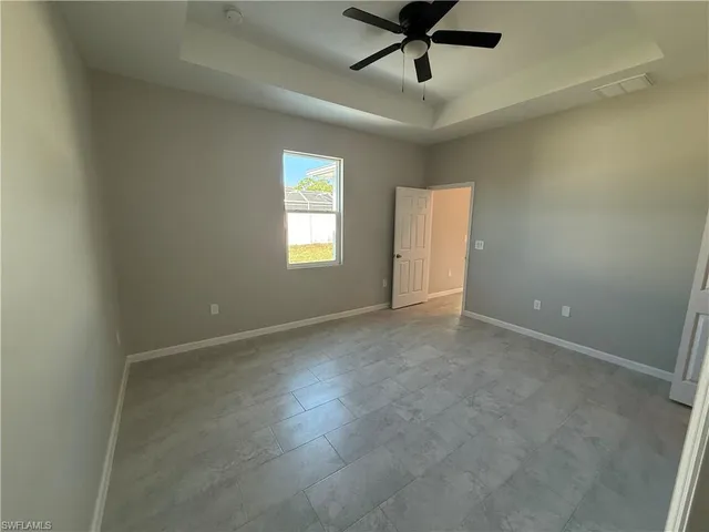 an empty room with a window and a fan