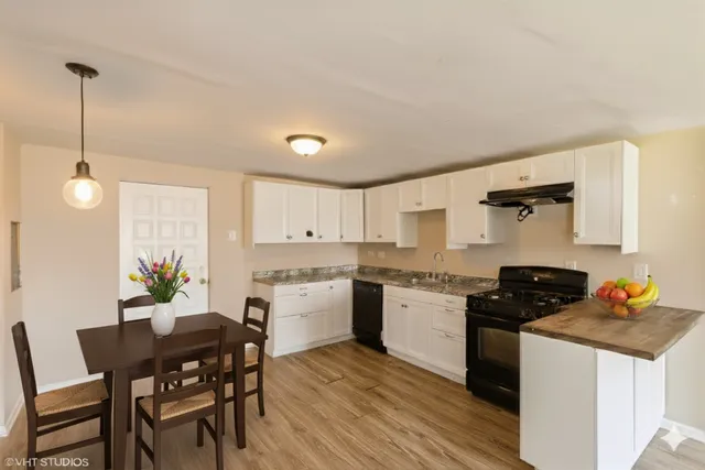 a kitchen with granite countertop kitchen island white cabinets and stainless steel appliances