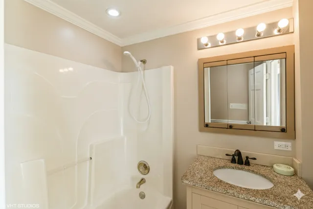 a bathroom with a granite countertop sink a mirror and a shower