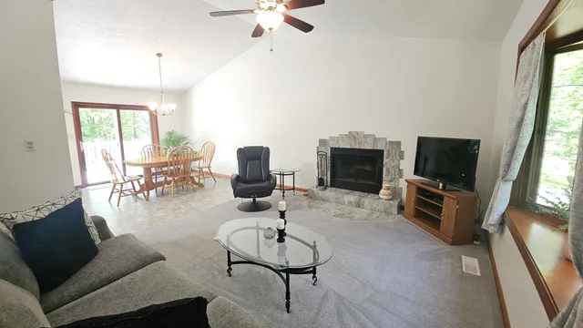 a kitchen with stainless steel appliances granite countertop a sink a stove a refrigerator a washer dryer and a dining table