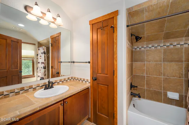 a bathroom with a granite countertop sink a mirror and a bathtub