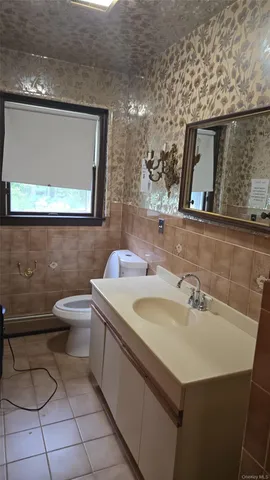 a bathroom with a toilet sink and mirror