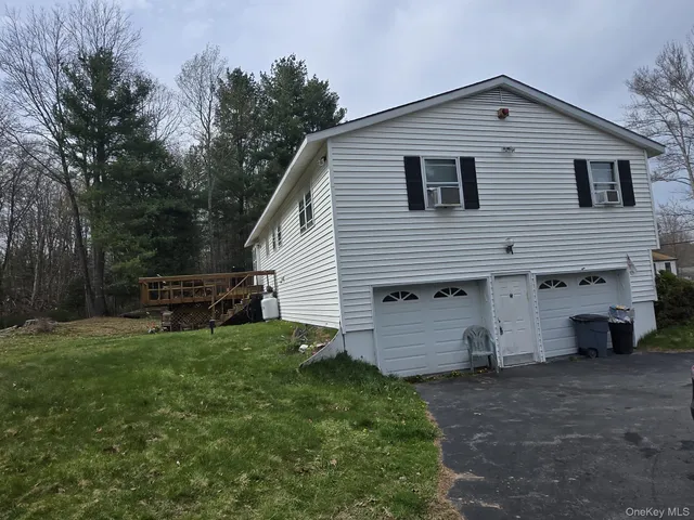 a view of a house with a backyard and a garage