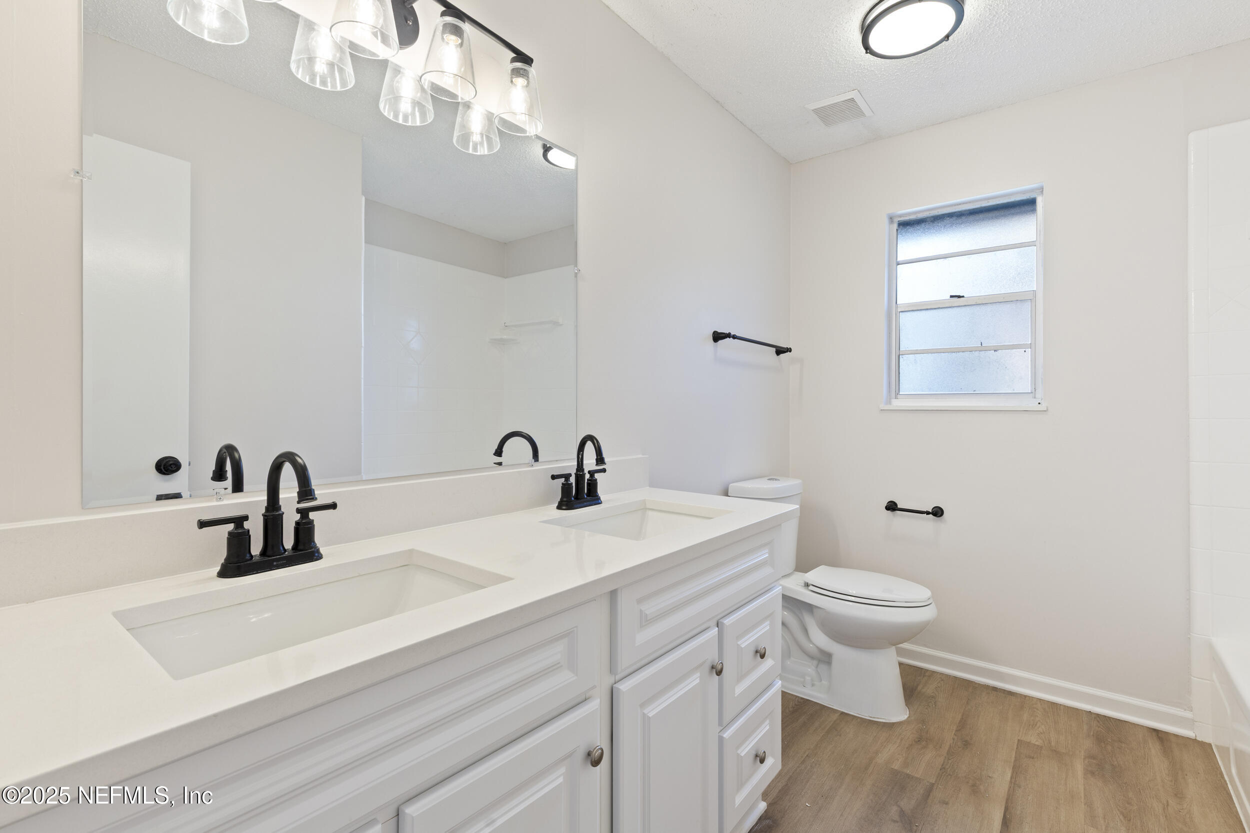 4135 Dawnridge Road East Jacksonville, FL 32277 - Photo 14 of 26 a bathroom with a sink a toilet and a mirror