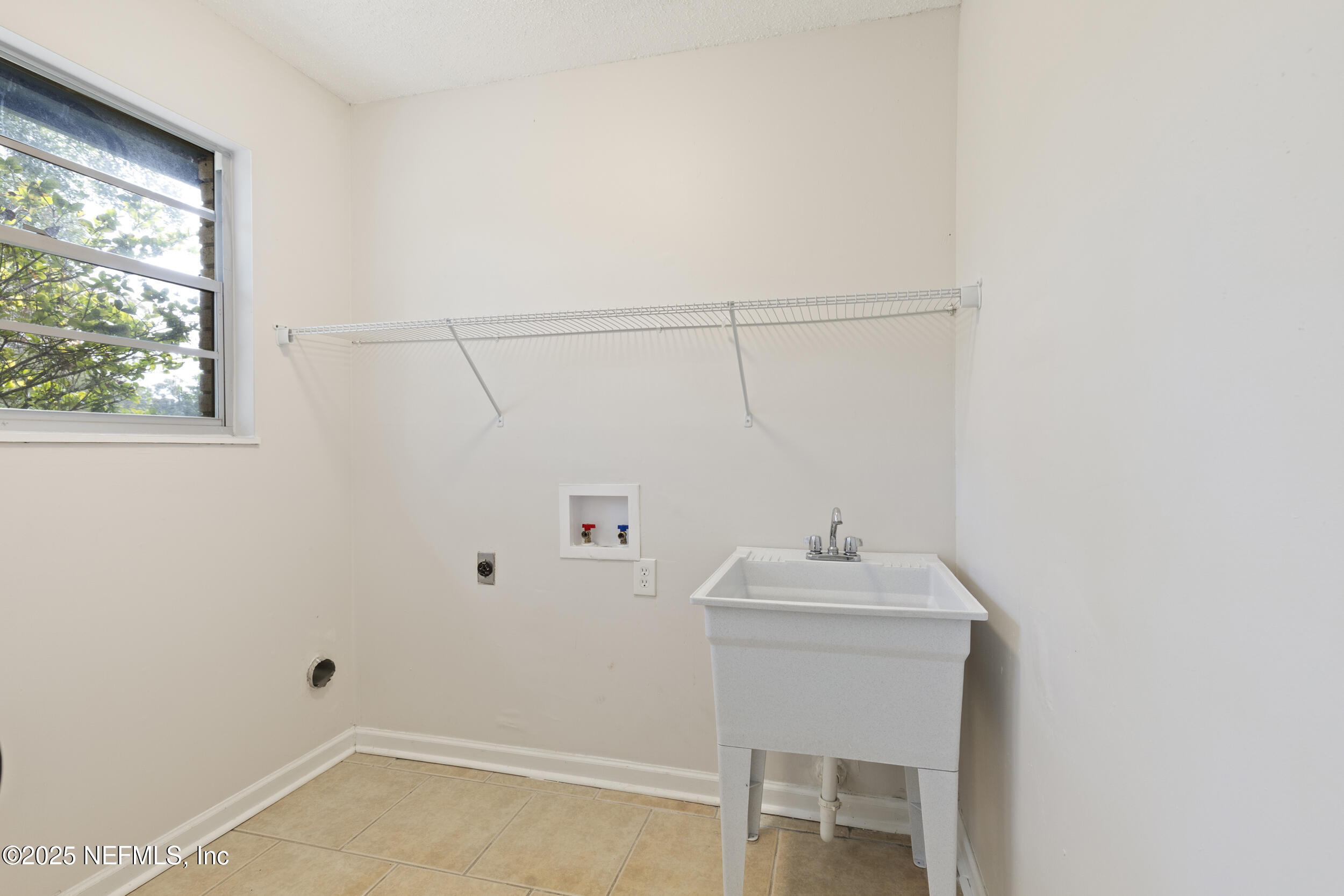 4135 Dawnridge Road East Jacksonville, FL 32277 - Photo 20 of 26 a bathroom with a sink vanity and a window