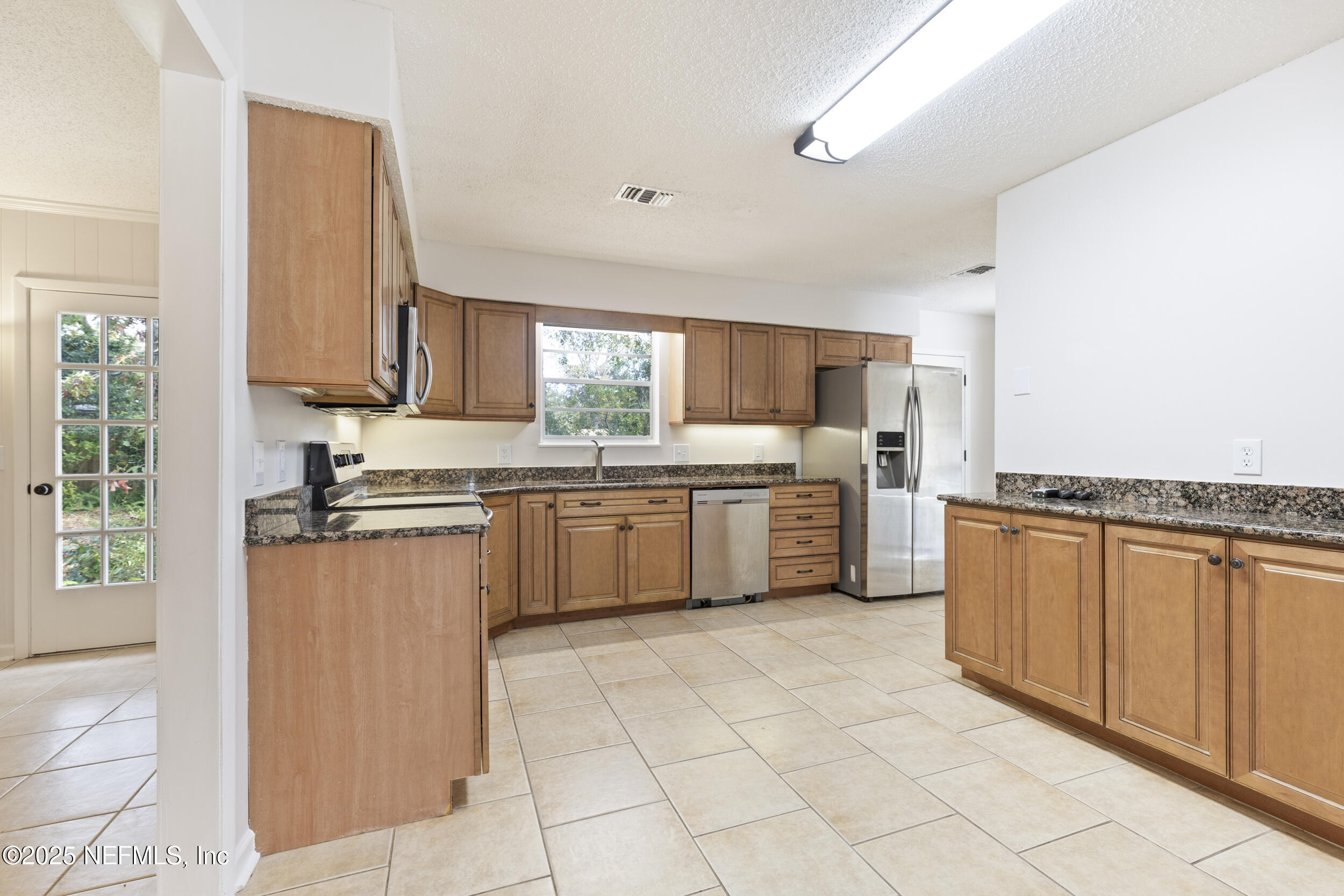 4135 Dawnridge Road East Jacksonville, FL 32277 - Photo 6 of 26 a kitchen with stainless steel appliances granite countertop a stove sink and cabinets