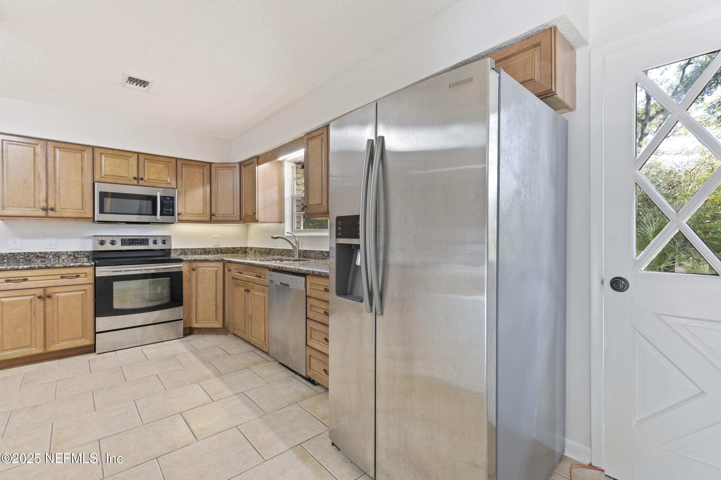 4135 Dawnridge Road East Jacksonville, FL 32277 - Photo 8 of 26 a kitchen with a refrigerator a sink and a stove