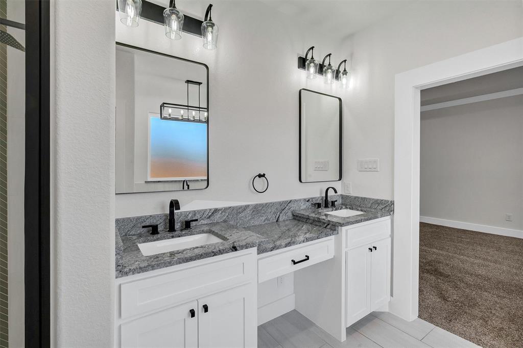 517 Highview Court Godley, TX 76044 - Photo 18 of 39 a bathroom with a granite countertop sink and a mirror