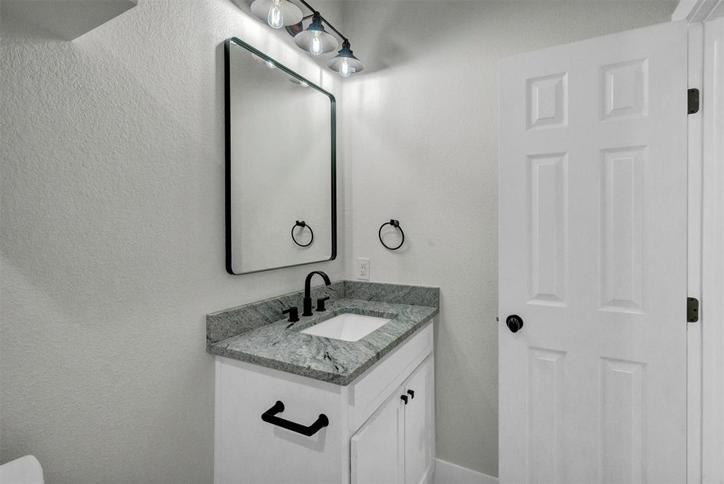 517 Highview Court Godley, TX 76044 - Photo 20 of 39 a bathroom with a granite countertop sink and a mirror