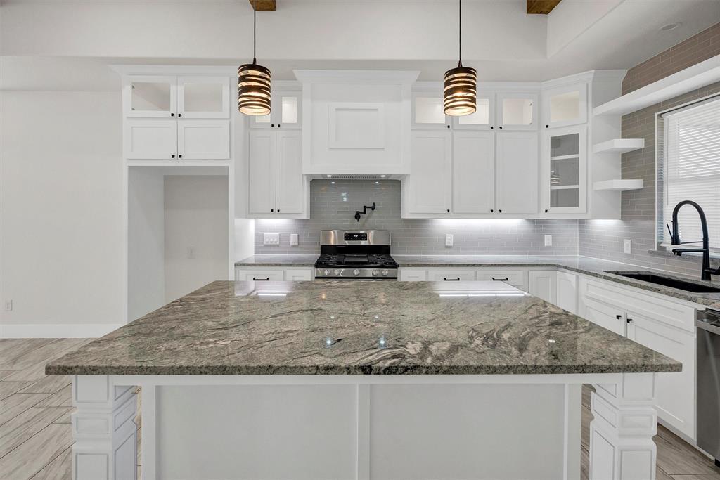 517 Highview Court Godley, TX 76044 - Photo 32 of 39 a kitchen with kitchen island granite countertop a sink a counter space and cabinets
