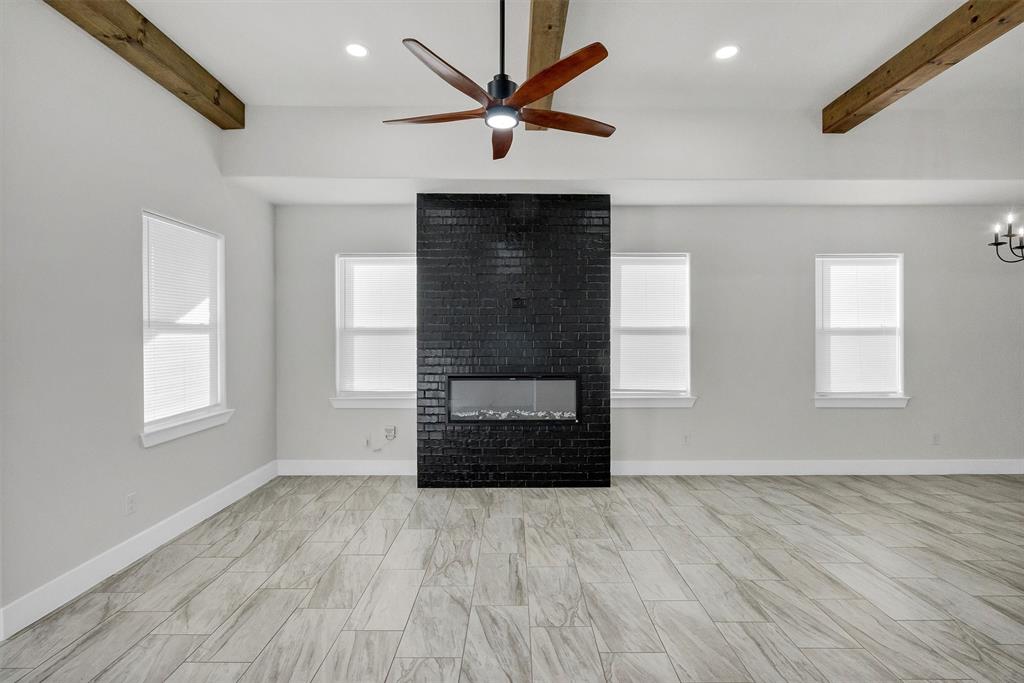 517 Highview Court Godley, TX 76044 - Photo 10 of 39 an empty room with windows and a ceiling fan with wooden floor