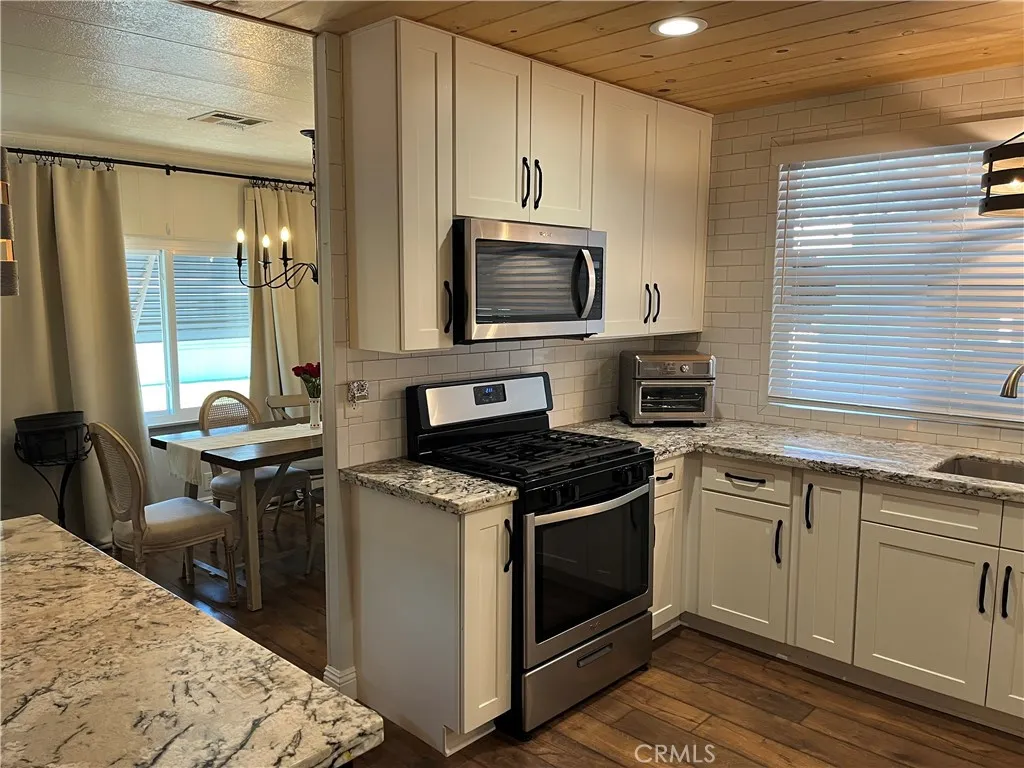4000 Pierce Street, Unit 284 Riverside, CA 92503 - Photo 17 of 32 a kitchen with a stove a sink and a microwave