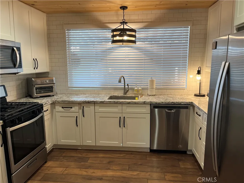 4000 Pierce Street, Unit 284 Riverside, CA 92503 - Photo 18 of 32 a kitchen with stainless steel appliances granite countertop a sink stove and refrigerator