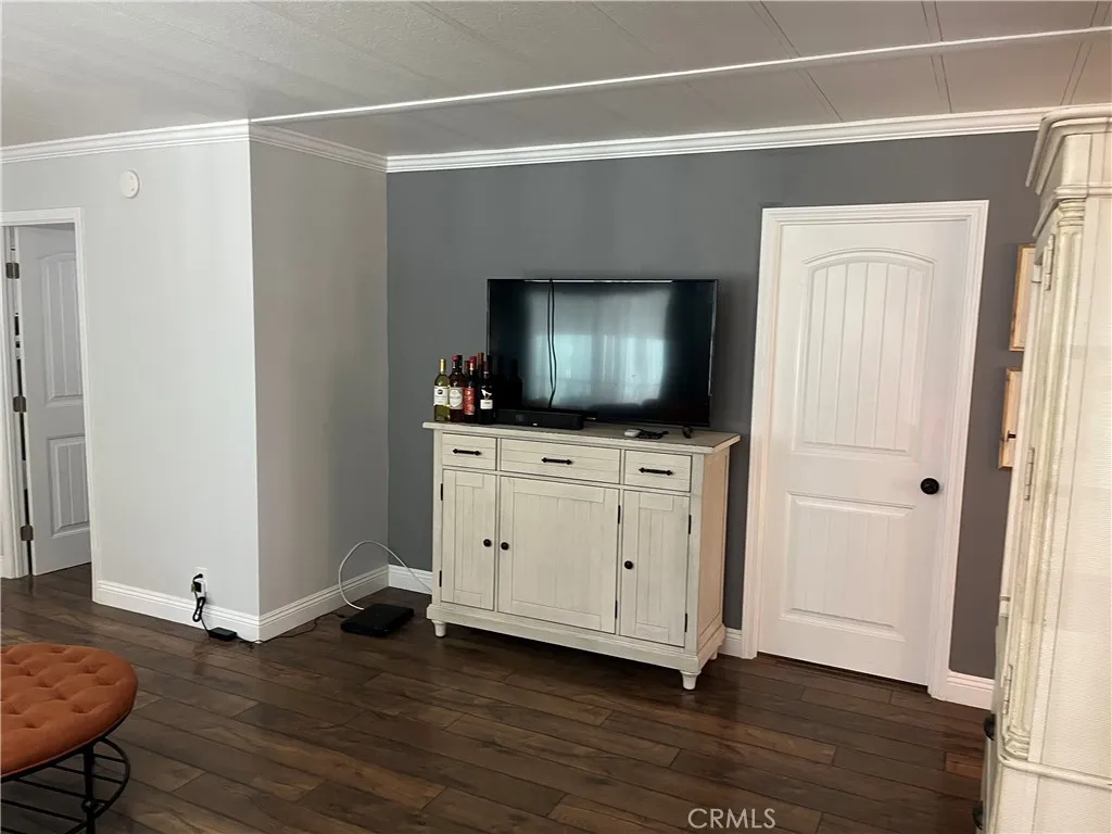 4000 Pierce Street, Unit 284 Riverside, CA 92503 - Photo 7 of 32 a room with wooden floor and flat screen tv