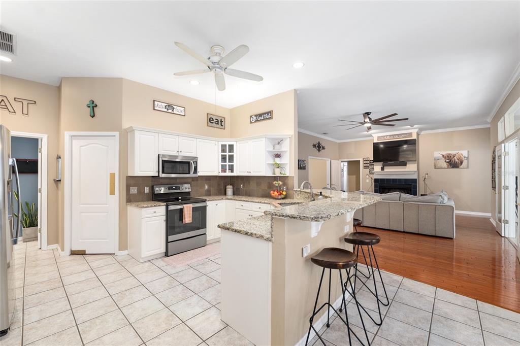9350 Southwest 46 Place Gainesville, FL 32608 - Photo 21 of 63 a kitchen with stainless steel appliances kitchen island granite countertop a refrigerator and a stove top oven
