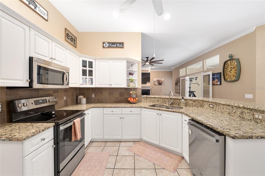 9350 Southwest 46 Place Gainesville, FL 32608 - Photo 24 of 63 a kitchen with a sink stove top oven and cabinets