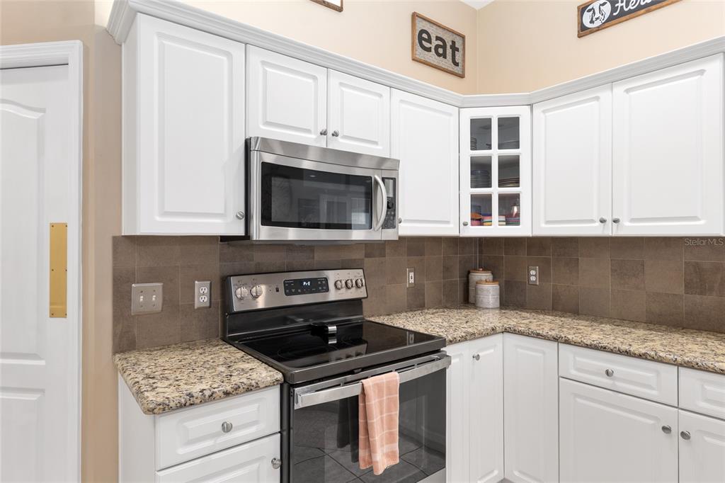 9350 Southwest 46 Place Gainesville, FL 32608 - Photo 25 of 63 a kitchen with stainless steel appliances granite countertop a stove and a microwave