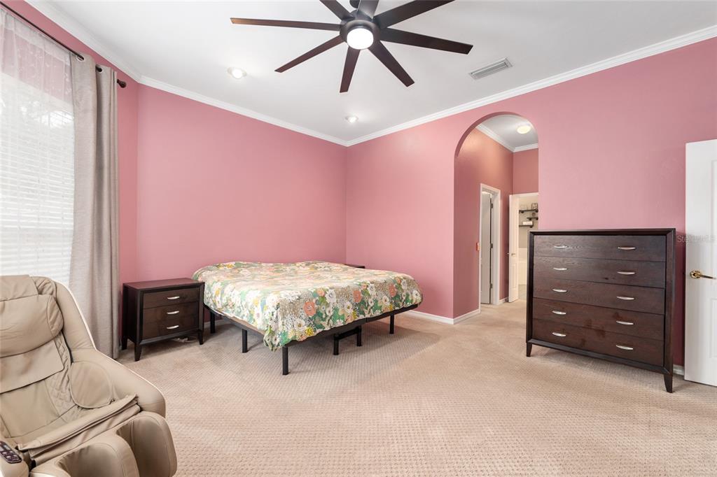 9350 Southwest 46 Place Gainesville, FL 32608 - Photo 34 of 63 a spacious bedroom with a bed and a ceiling fan